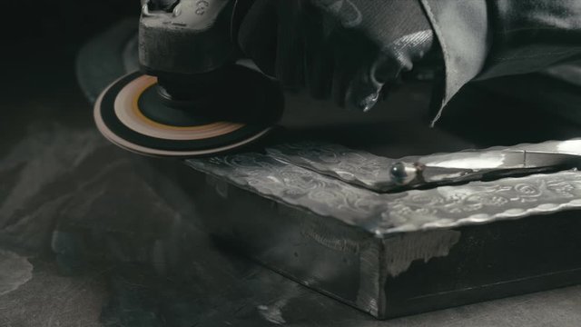 Forge workshop. Smithy manual production. Polish metal with an angle grinder with an abrasive nozzle. Polishing iron.