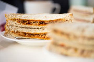 A healthy wholegrain bread chicken salad sandwich sliced into triangles and stacked 