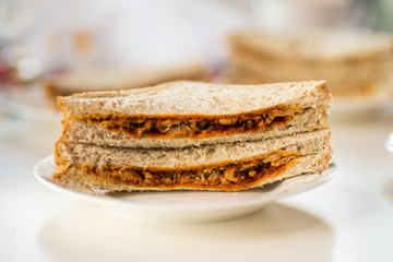 A healthy wholegrain bread chicken salad sandwich sliced into triangles and stacked 