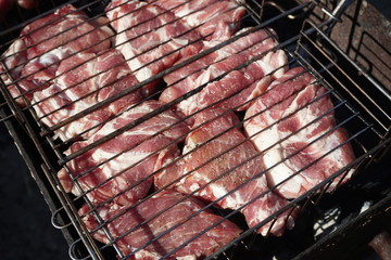 meat is fried on the grill over the coals during the barbecue season