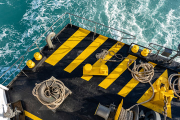 The deck of the ferry boat along with the a thick mooring rope and blue sea water wave, Thailand....