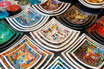 Colorful mosaic decorative plates on the market for sale on street market in Ubud, island Bali, Indonesia, closeup . Souvenirs for tourist