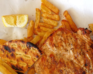 grilled chicken breast and french fries top view close up