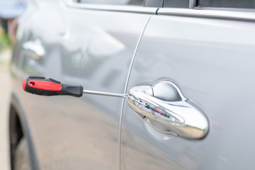 Fototapeta premium Car technician wearing white gloves and using screwdriver to fix, repair or open the door