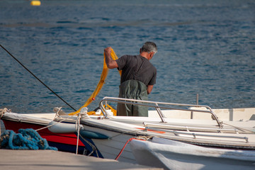 Fisherman preparing his fishing net on a fishing boat.