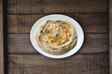 Delicious hummus on rustic wooden kitchen table. This is an Arab and Middle East origin appetizer meal