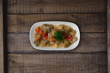 Turkish food Kizartma. Fried aubergine or eggplant slices with tomato paste salsa sauce and cube potatoes on rustic wooden kitchen table