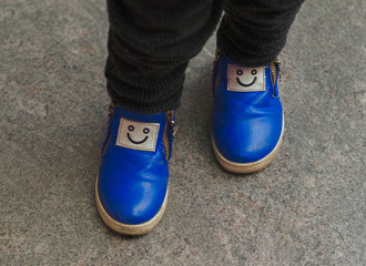 legs of a child in funny blue boots