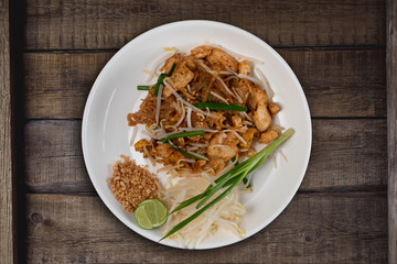 Top view Thai food Pad Thai chicken isolated on rustic wooden table