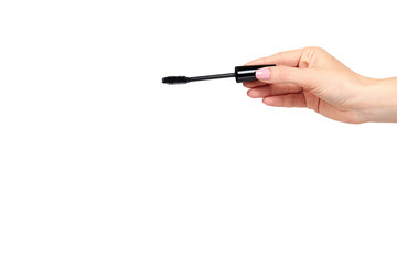 Hand with black mascara, eye makeup brush.