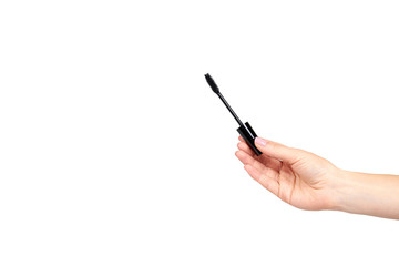 Hand with black mascara, eye makeup brush.