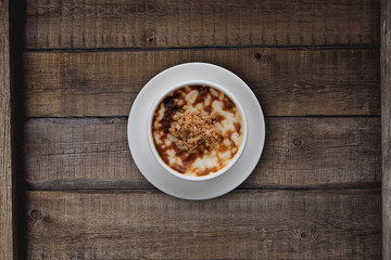 Top view of traditional tukish rice pudding with walnut isolated on rustic wooden table