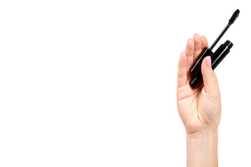 Hand with black mascara, eye makeup brush.