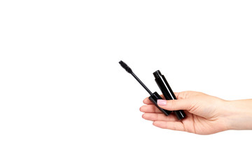 Hand with black mascara, eye makeup brush.