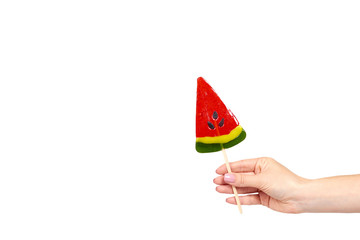 Hand with color lollipop, bright cool candy, watermelon shape.