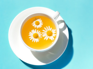 Herbal tea with fresh chamomile flowers in a cup