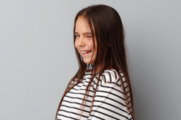 Little girl making a grimace over a grey background