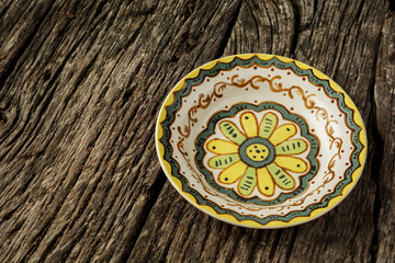 Decorative dinner plate on a rustic wooden table. Flat lay background.