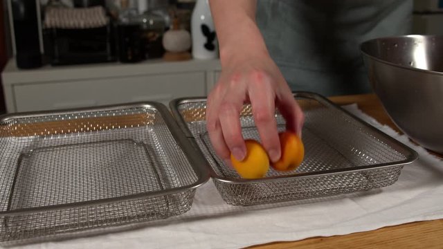 a Japanese female chef drying Nanko-Ume plums at her home kitchen, Tokyo, Japan. July 2019. Camera fixed, close-up, high view