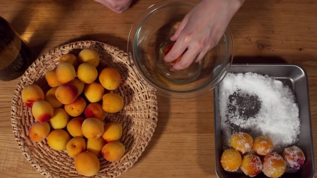a Japanese female chef salting Nanko-Ume plums at her home kitchen, Tokyo, Japan. July 2019. Camera fixed, close-up, bird's eye view