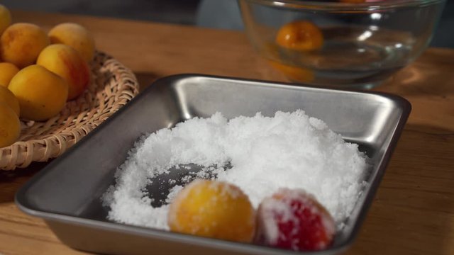 a Japanese female chef salting Nanko-Ume plums at her home kitchen, Tokyo, Japan. July 2019. Camera fixed, extreme close-up, high view