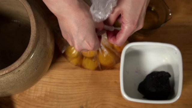 a Japanese female chef preparing UMEBOSHI at her home kitchen, Tokyo, Japan. July 2019. Camera fixed, close-up, bird's eye view