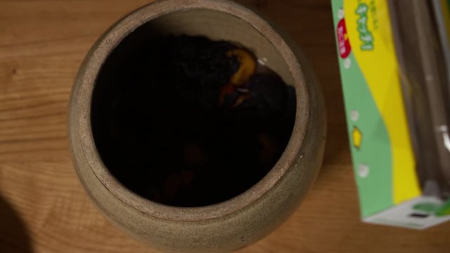 a Japanese female chef storing UMEBOSHI at her home kitchen, Tokyo, Japan. July 2019. Camera fixed, close-up, bird's eye view