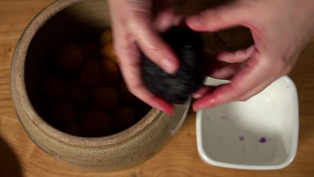a Japanese female chef preparing UMEBOSHI at her home kitchen, Tokyo, Japan. July 2019. Camera fixed, close-up, bird's eye view