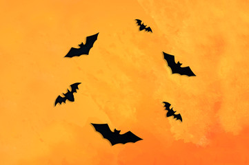Fototapeta na wymiar Bats cut out of black paper on an orange background. Greeting card, background, banner for the holiday Halloween.
