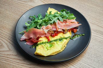 Frittata with prosciutto, pesto sauce, arugula and bell pepper. Tasty and healthy lunch. Omelette