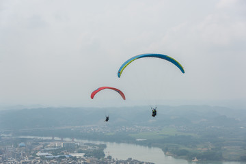 2 paragliders flying over the aerial town