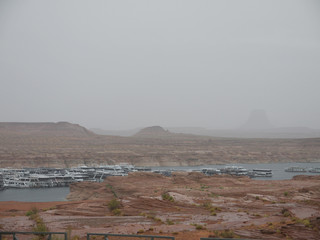 Lake Powell marina view, cloudy rainy day, moored boats, foggy morning, distant buttes in the desert, Arizona desert landscape