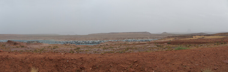 Lake Powell marina Panoramic view, cloudy rainy day, moored boats, foggy morning, distant buttes in the desert, Arizona desert landscape