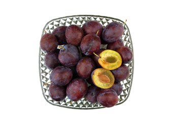 Obraz premium Fresh organic plums in glass vase isolated on white background. Still life of ripe and juicy fruits