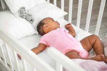 Little African-American baby sleeping in bed