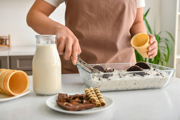 Woman preparing tasty ice cream in kitchen