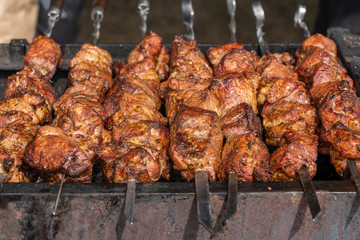 Grilled kebab cooking on metal skewer closeup. Roasted meat cooked at barbecue. BBQ fresh beef meat chop slices. Traditional eastern dish, shish kebab