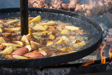 Roast potatoes in a large pan.Young potatoes are fried in oil, street food