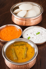 Indian idly with chutney and sambar - Fresh steamed Indian Idly (Idli / rice cake) arranged in authentic copper bowl. Served with tomato chutney, coconut chutney and sambar. Natural light used.