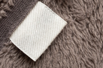 Blank white laundry care clothing label on fur texture background