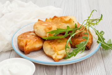 Plate with fried pies on wooden boards.