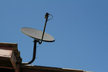 Satellite dish is on the roof of the house.