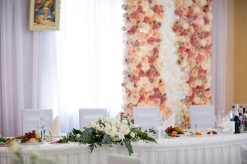 Fototapeta na wymiar Tables setting at a luxury wedding. Table for guests. Dishes and drinks. Floral decorating, white chairs and table. Wedding table preparation. top view. horizontal photo