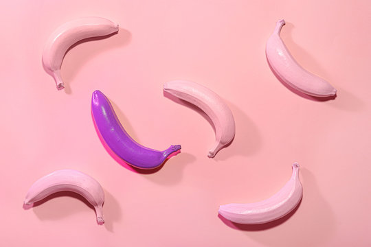 Ripe painted bananas on color background