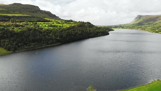 Rural scene with meadows and lake and river surrounded with hills. Aerial view - slide