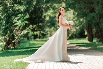 beautiful young woman in wedding dress standing in Park.