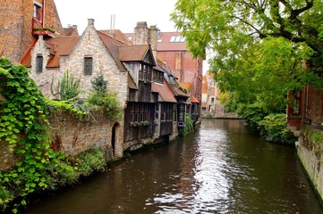 Fototapeta na wymiar Medieval wooden and brick buildings at canal street in Bruges. Autumn landscape of old historical town in Europe. Autumn travel landscape. architecture in Brugge, Belgium