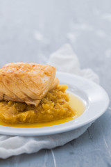 cod fish with mashed potato and olive oil on white dish