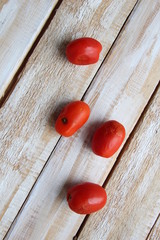 Ugly spoiled tomatos on wooden background