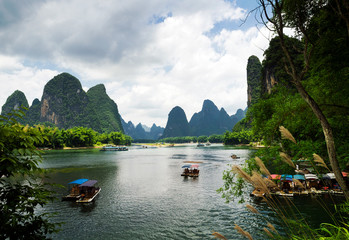 Tourist boats sailing along Lijiang river and the impressive karst mountains around Xinping, Guangxi, China